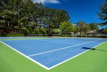A tennis court with trees in the background